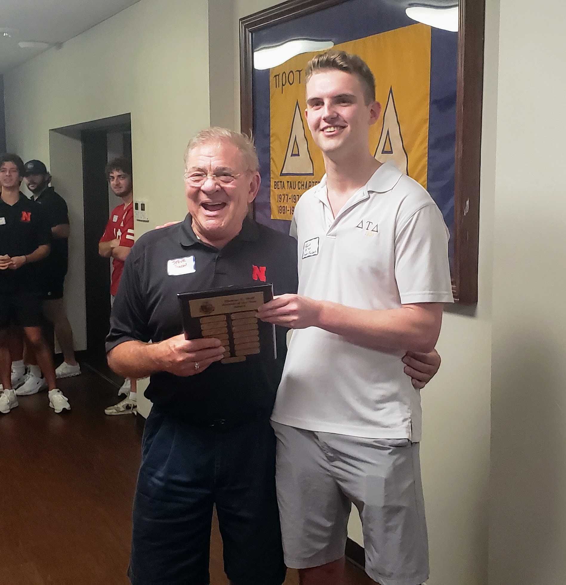 Steve Fallon (1972) receives the Thomas E. Wolf Alumnus of the Year Award from current Chapter President, Adam Steinwold (2024) at the 2023 Alumni Tailgate.
